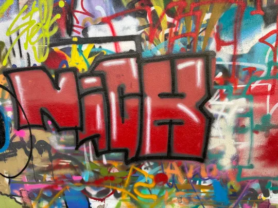 Graffiti-Buchstaben auf bunter Wand.