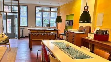 Zimmer mit Tischfußball und Essbereich.