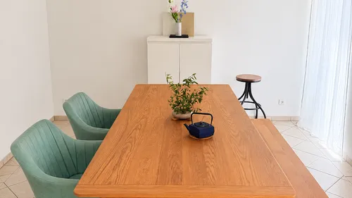 Wooden dining table with teapot and plants.