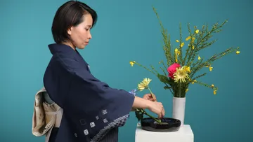 Frau arrangiert Blumen in moderner Umgebung.