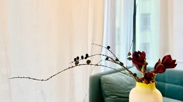 Red flowers in vase on a table.