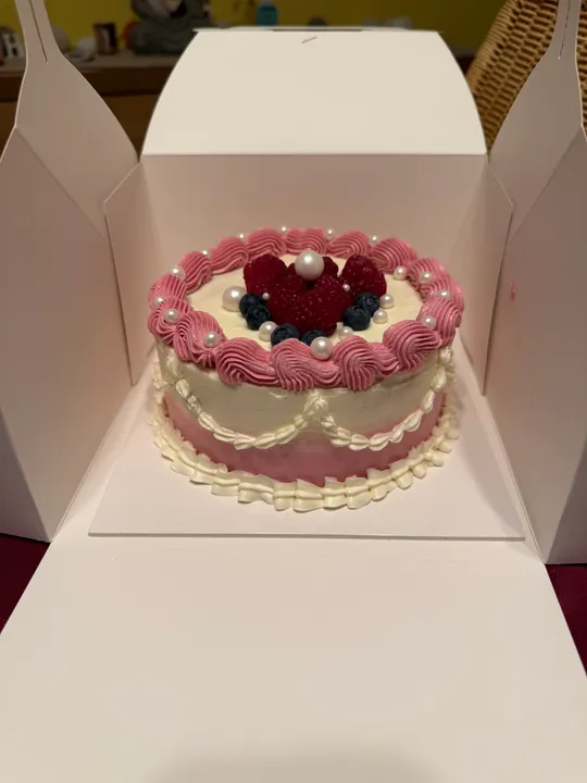 Decorative cake in open white box.