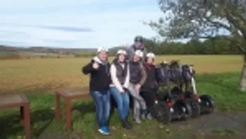Gruppe posiert mit Segways auf dem Land.