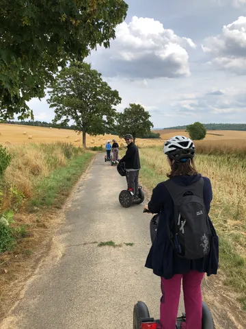 Leute fahren Segways auf einem Feldweg.