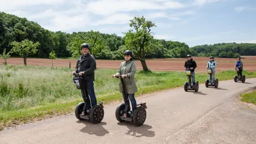 People riding Segways on a rural path.