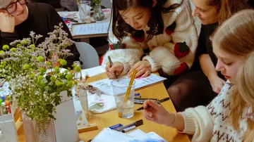 People drawing together at a table.