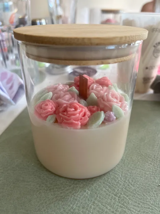 Glasgefäß mit Blumendekor auf dem Tisch.