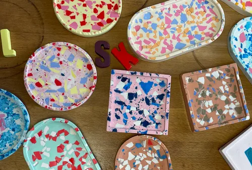 Bunte Terrazzo-Tabletts auf Holztisch.