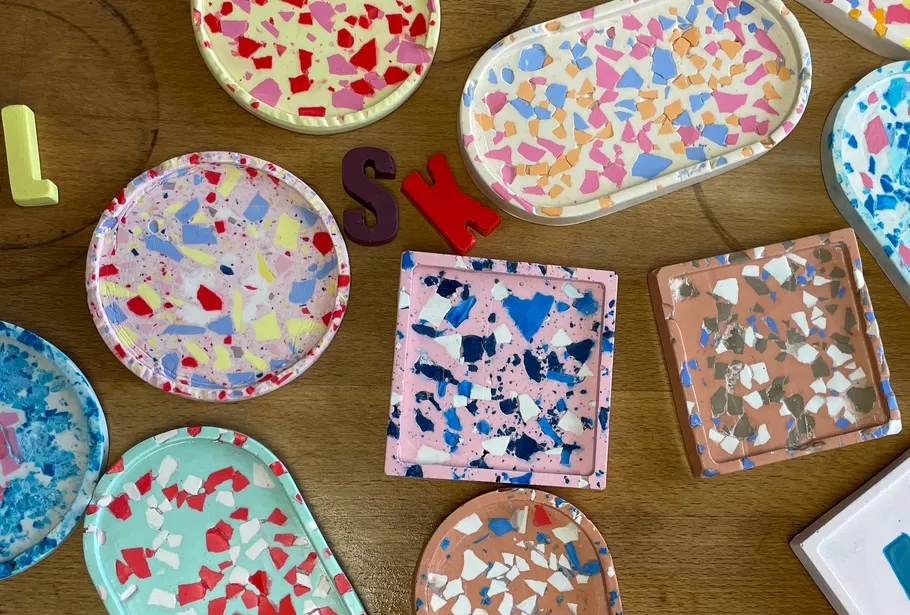 Bunte Terrazzo-Tabletts auf Holztisch.