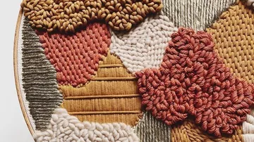 Intricate woven textile art with various textures.