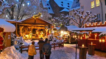 Weihnachtsmarkt mit Krippe, Personen schlendern.