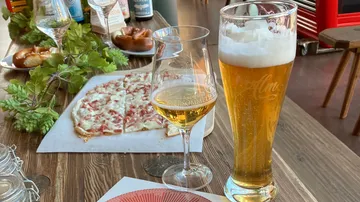 Pizza und Getränke auf Holztisch.