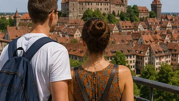 Tourists overlook old European city rooftops.