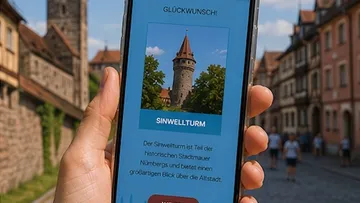 Hand holds phone showing Sinwell Tower image.