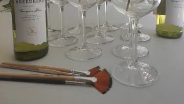 Weingläser und Pinsel auf einem Tisch.