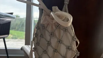 Beaded purse hanging by a window.