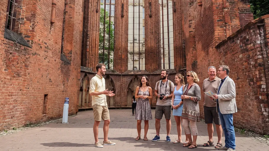 Reiseleiter spricht mit Gruppe in antiken Ruinen.