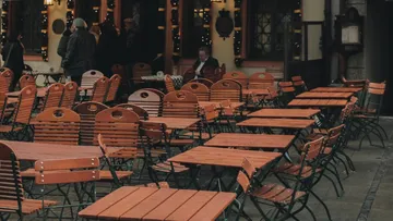 Empty wooden tables outside a café.