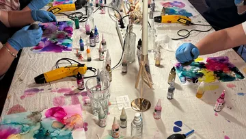 Personen erstellen bunte Kunst am Tisch.