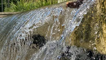 Wasser fließt über Steinkante, draußen.