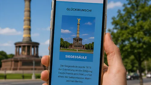 Phone displaying victory column photo outdoors.