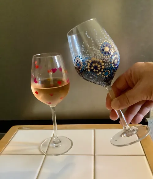 Zwei verzierte Weingläser stoßen drinnen an.