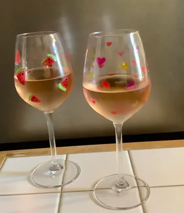 Zwei verzierte Weingläser auf einem Tisch.