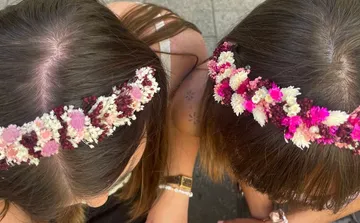 Zwei Frauen tragen Blumenhaarbänder im Freien.