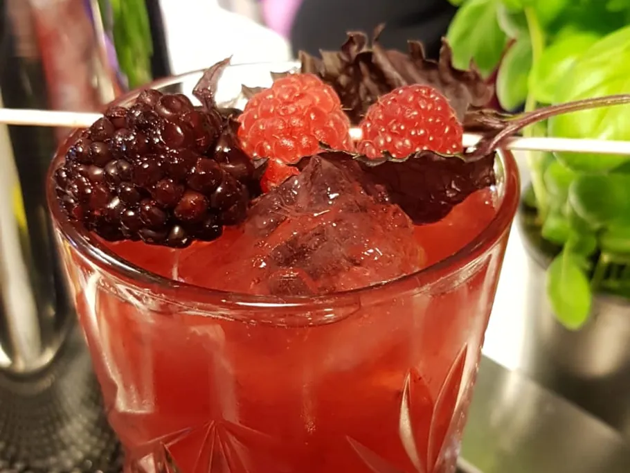 Fruity cocktail with berries and ice in a glass.