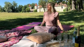 Frau meditiert auf Yogamatte im Park.