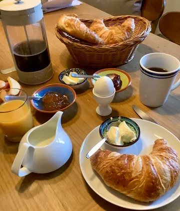 Frühstück mit Croissants, Kaffee und Marmelade.