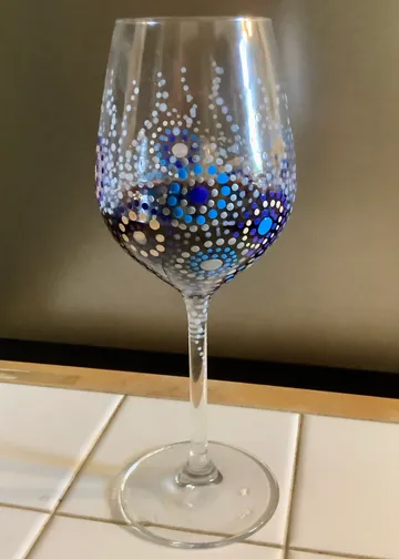 Decorative wine glass on white tiles.