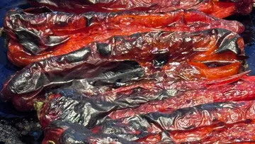 Charred red peppers lying close together.