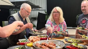 Menschen servieren Essen am Außenbuffet.