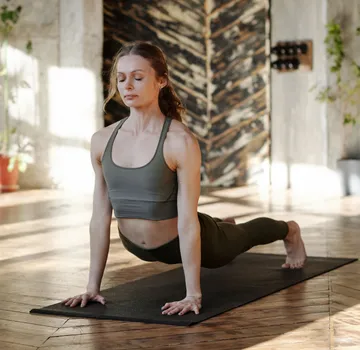 Frau macht Yoga-Pose drinnen.
