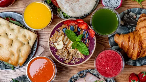 Breakfast spread with smoothie bowls and pastries.