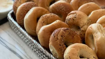 Bagels in einem Korb auf Tischplatte.