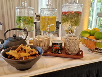Beverage dispenser with fresh fruit and snack bowl.