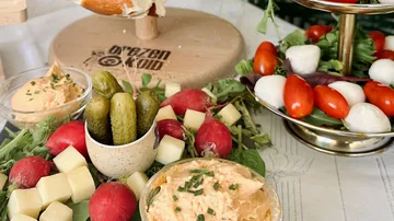 Colorful platter with vegetables, cheese, and dips.
