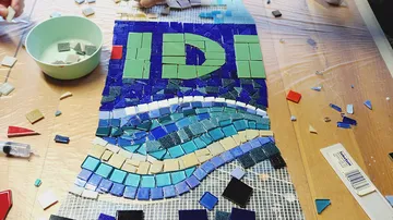 Mosaikarbeit in Bearbeitung auf Tisch.