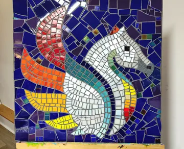 Buntes Mosaikpferd auf blauem Hintergrund