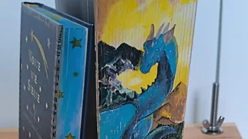 Bücher mit Drachenillustration auf dem Einband.