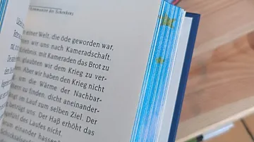 Offenes Buch auf Holztisch.