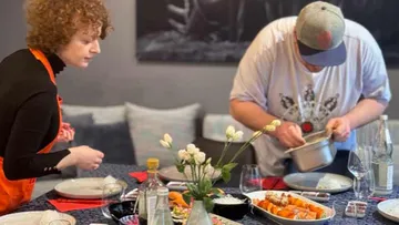 Personen bereiten Essen am Esstisch vor.