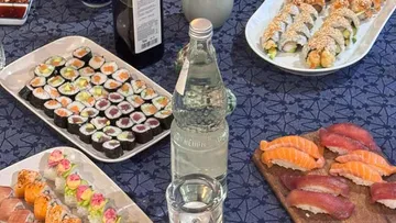 Verschiedene Sushi-Teller auf dekorativem Tisch.