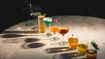 Verschiedene Cocktails auf einem runden Tisch.