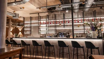Bar counter with stools and shelves.