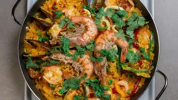 Seafood paella with shrimp, mussels, and herbs.