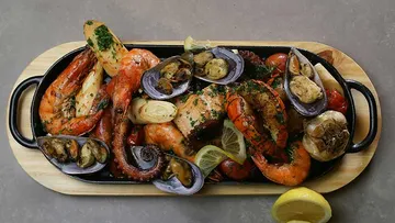 Seafood platter with lemons on a wooden tray.