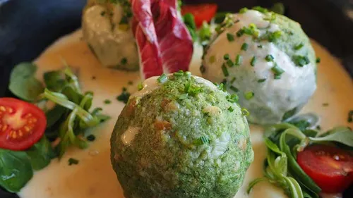 Herb dumplings with greens and sauce.